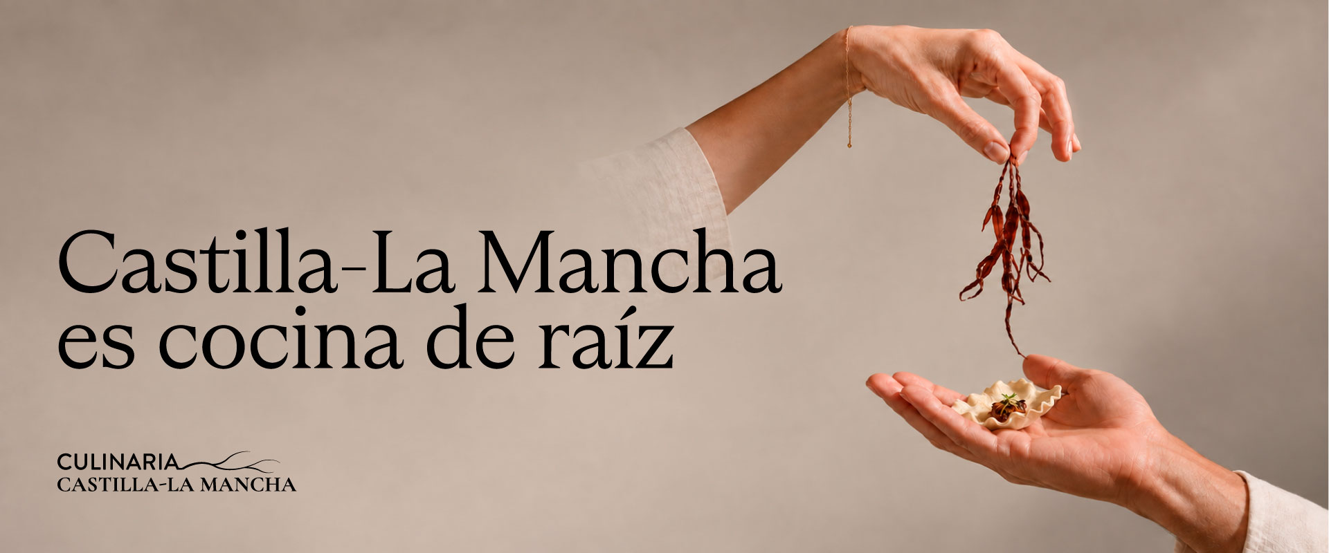 Banner de Culinaria Castilla-La Mancha con el lema “Castilla-La Mancha es cocina de raíz” y dos manos preparando un bocado gastronómico sobre fondo beige.